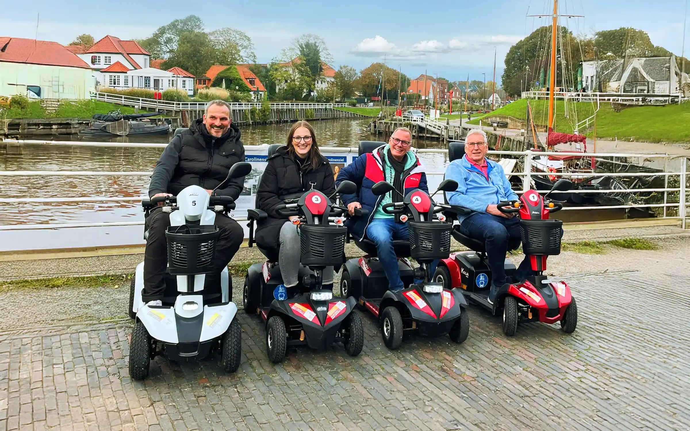 Vier Gäste mit E-Mobilen am Hafen von Carolinensiel